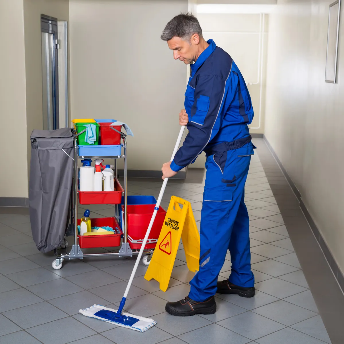 Operatore qualificato di Siegel Service in divisa professionale durante pulizia pavimenti con carrello attrezzato completo e prodotti specifici a Bari. Impresa di pulizie Bari per servizi professionali in corridoi, edifici commerciali e spazi aziendali con massima organizzazione e attenzione alla sicurezza. Pulizia pavimenti accurata che garantisce igienizzazione completa con attrezzature professionali, mop specializzati e protocolli di sicurezza per ambienti sempre impeccabili.